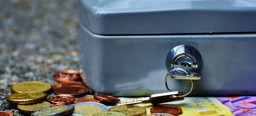 Locked metal cash box with a key in the lock