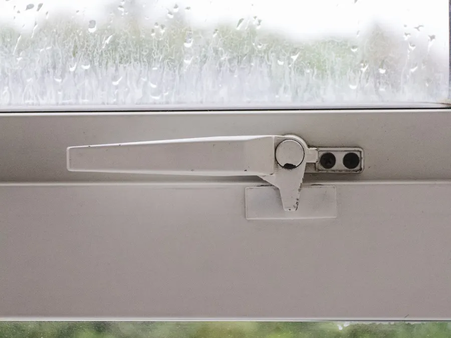 Locking handle on a white window frame
